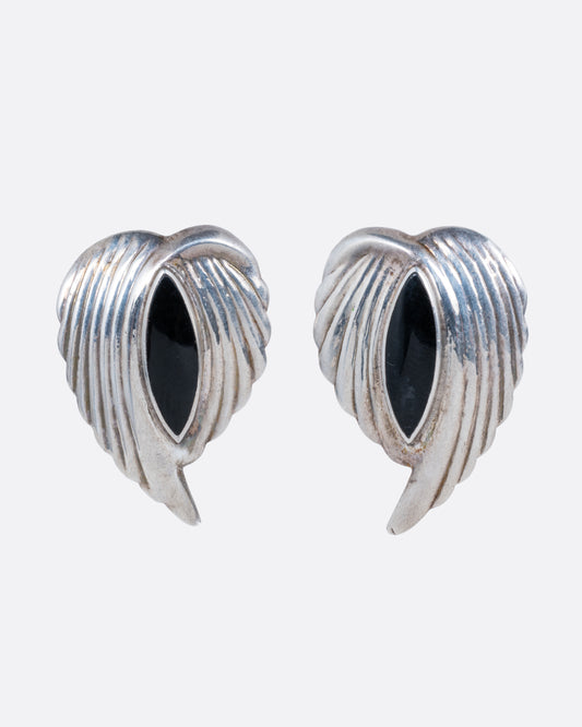 A pair of silver leaf stud earrings with bezel set marquis onyxes at the center. Shown from the front.