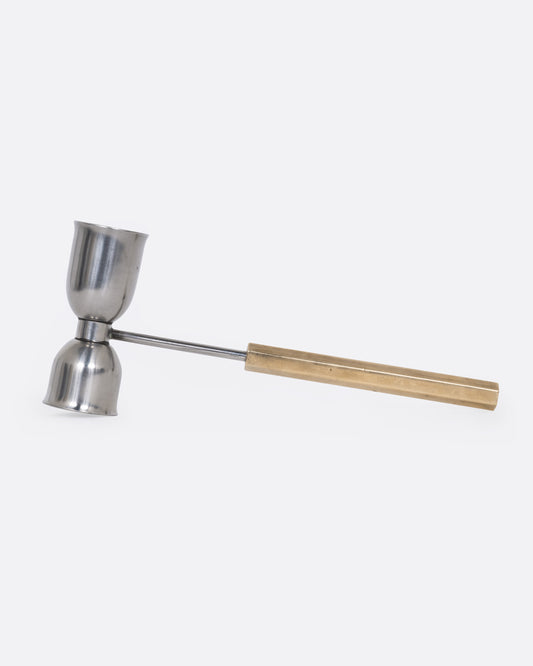 An hourglass shaped jigger with a long handle, shown from the side.