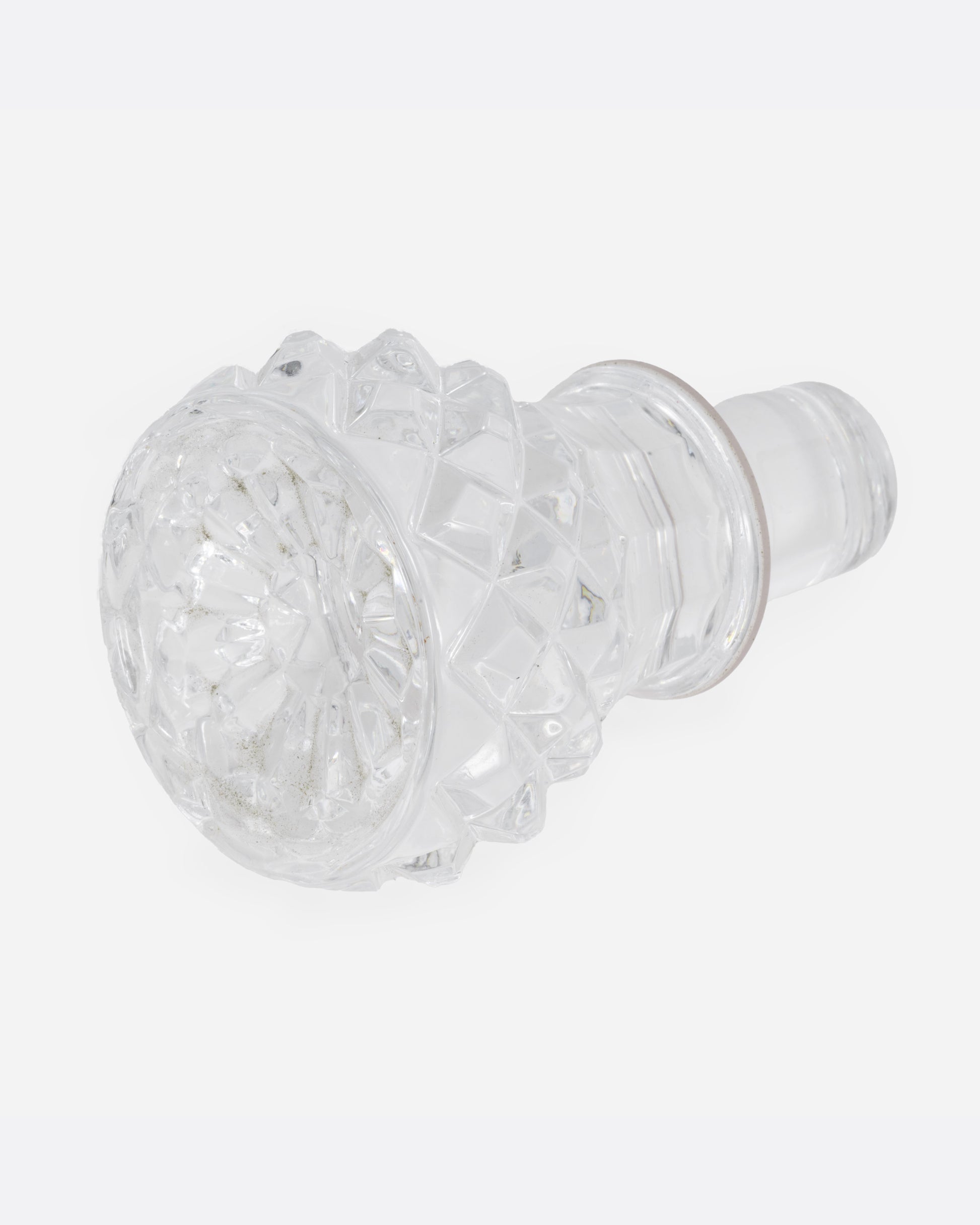 The top of a crystal cut glass decanter, shown lying on its side.