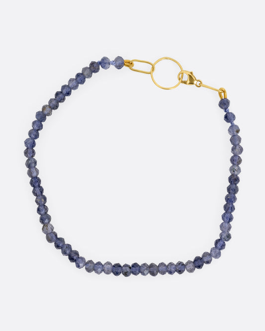An iolite beaded bracelet with a yellow gold clasp. Shown from the top.