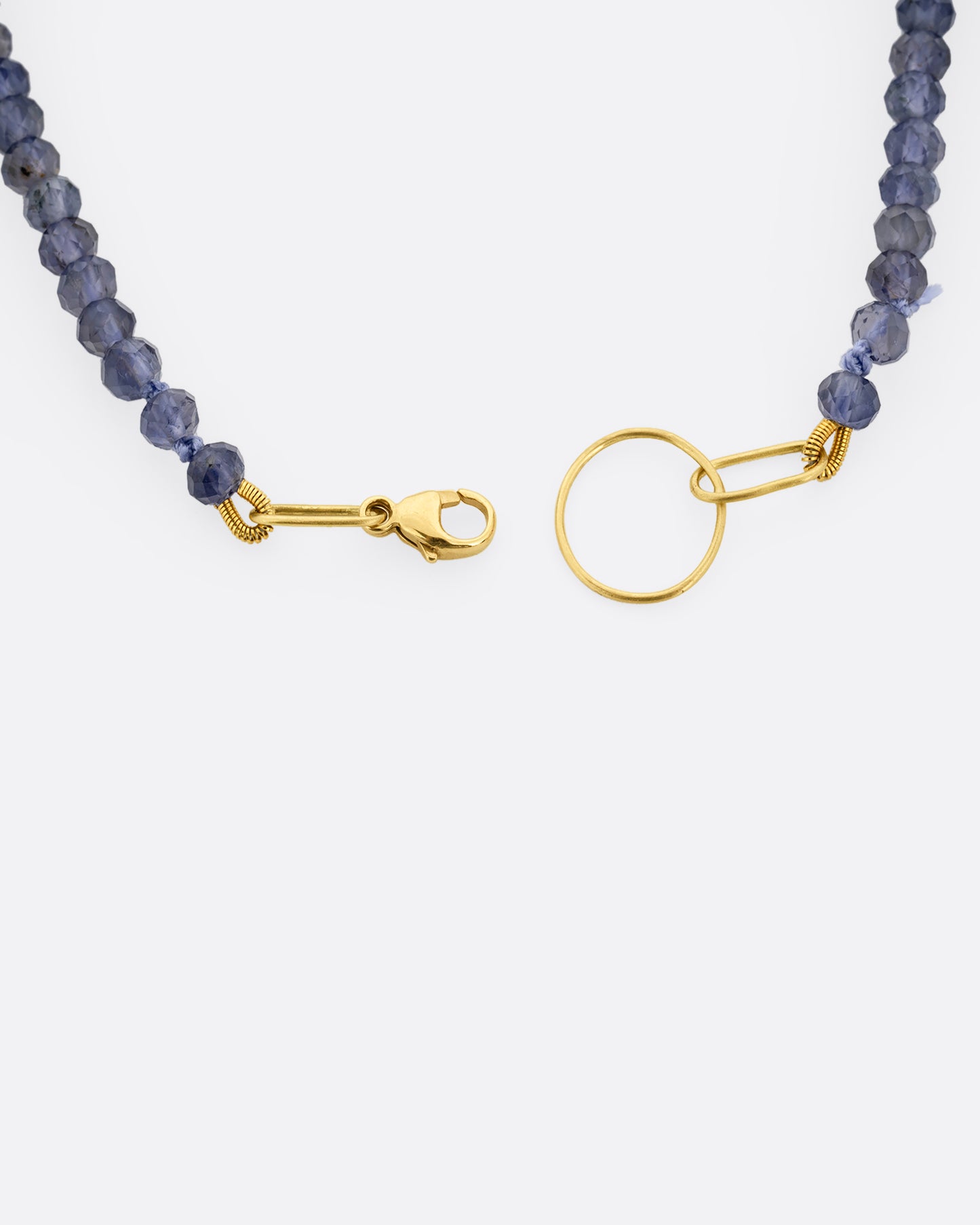 An iolite beaded bracelet with a yellow gold clasp. A close up view of the clasp shown from the top.