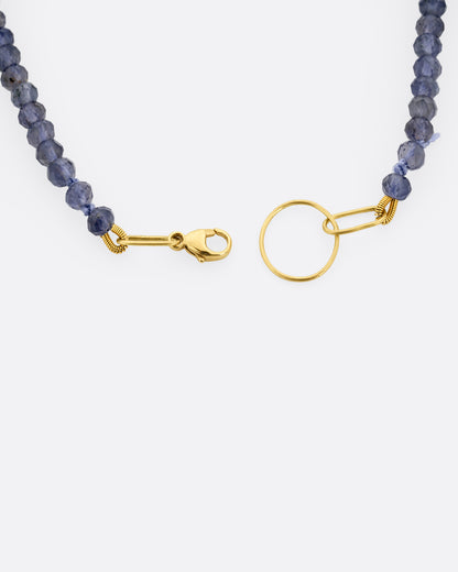 An iolite beaded bracelet with a yellow gold clasp. A close up view of the clasp shown from the top.