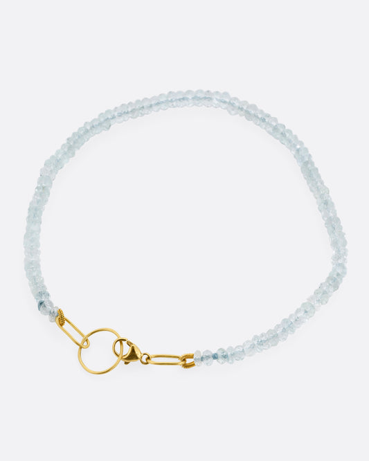A beaded aquamarine bracelet with a yellow gold clasp. Shown from the top.