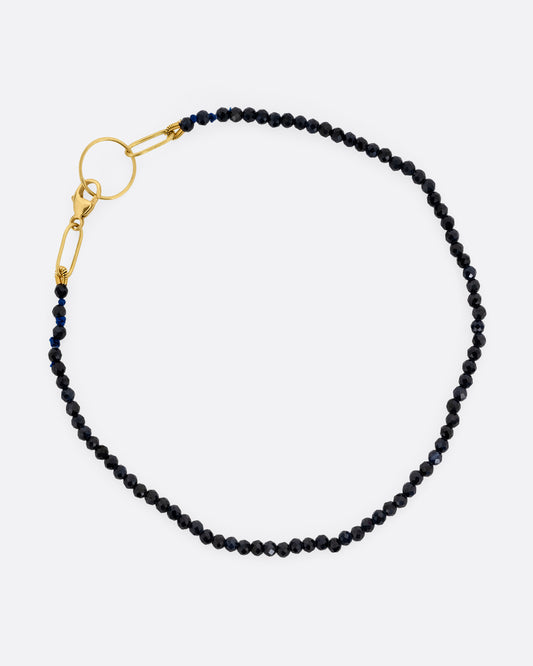 A beaded blue sapphire bracelet with a yellow gold clasp. Shown from the top.