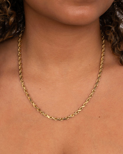 A yellow gold twisted rope chain. Shown on a neck.