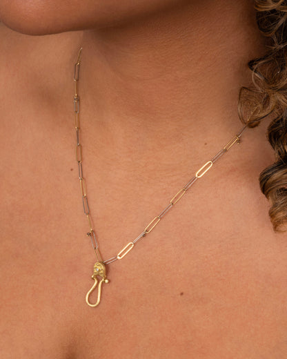 Yellow gold diamond charm holder pendant worn on a paperclip chain