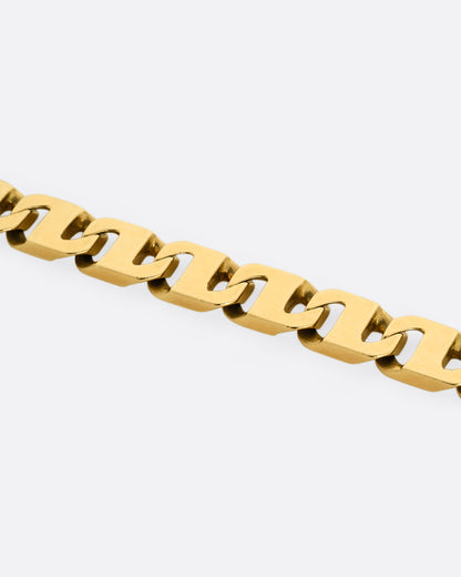 A close up of yellow gold anchor link bracelet. Shown lying flat from the front. 