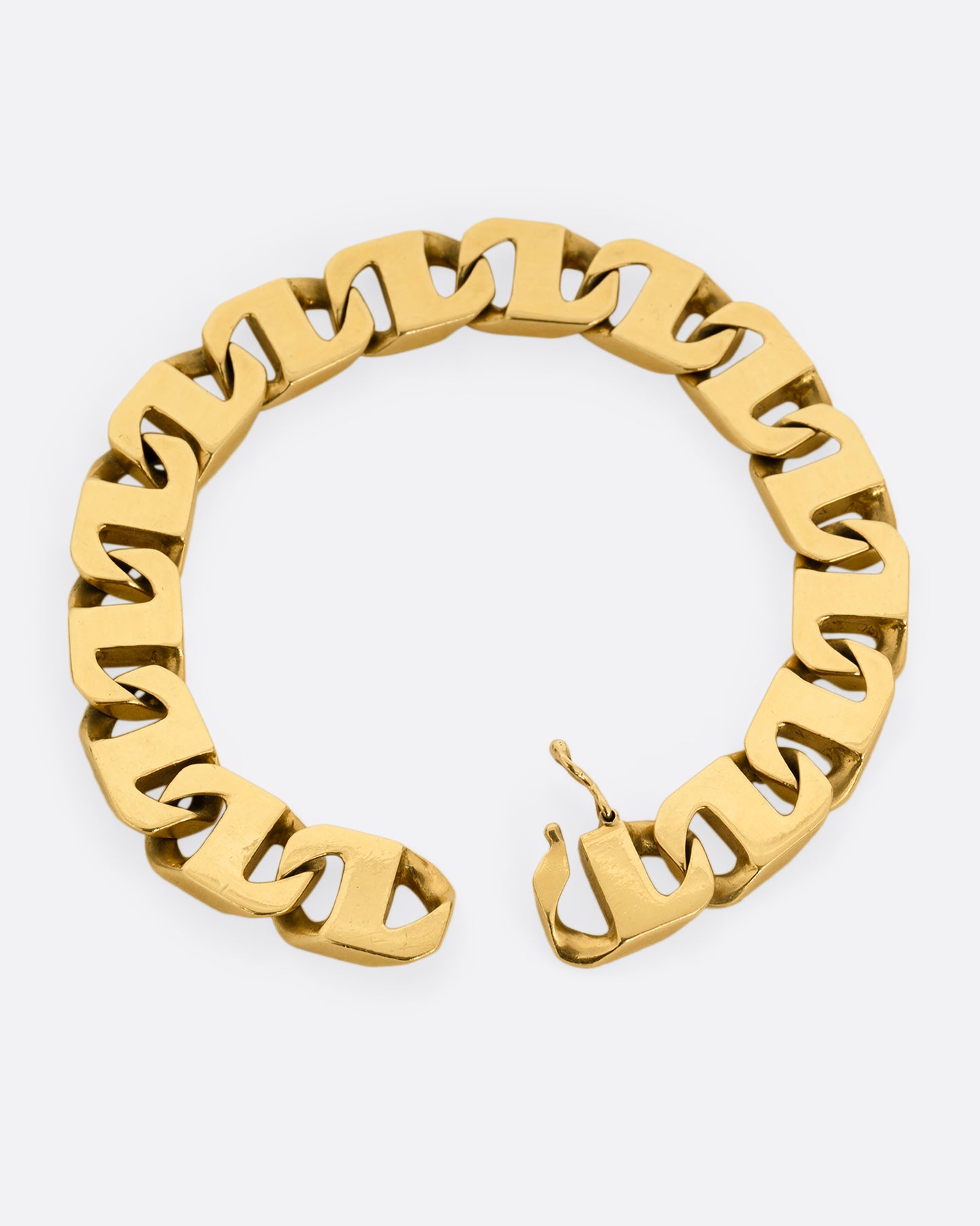 A yellow gold anchor link bracelet. Shown lying flat from the top with the clasp open.