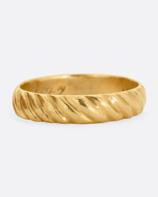 A yellow gold band with a continuous diagonal pattern. Shown from the front.