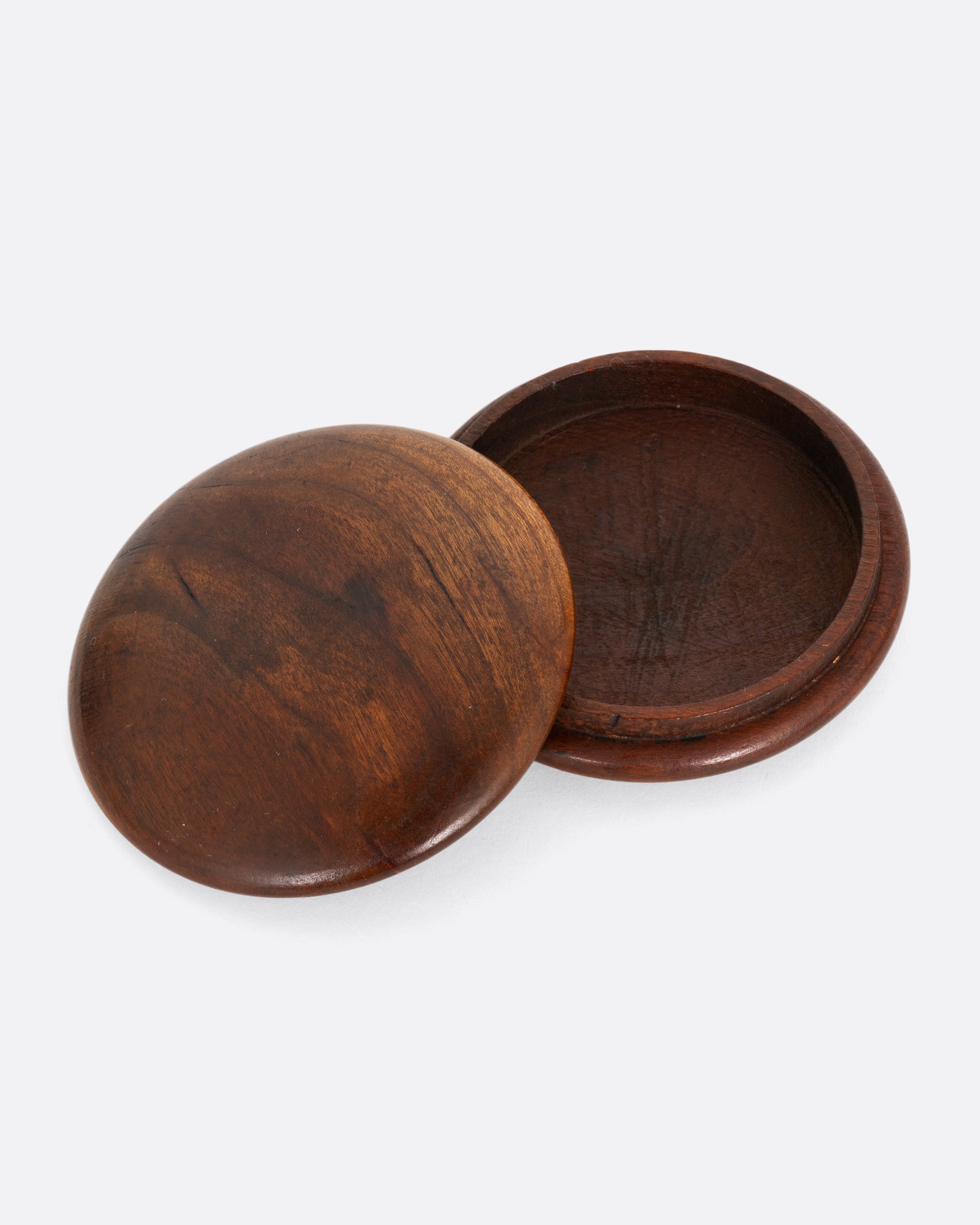 A round wooden snuff box shown open from the top.