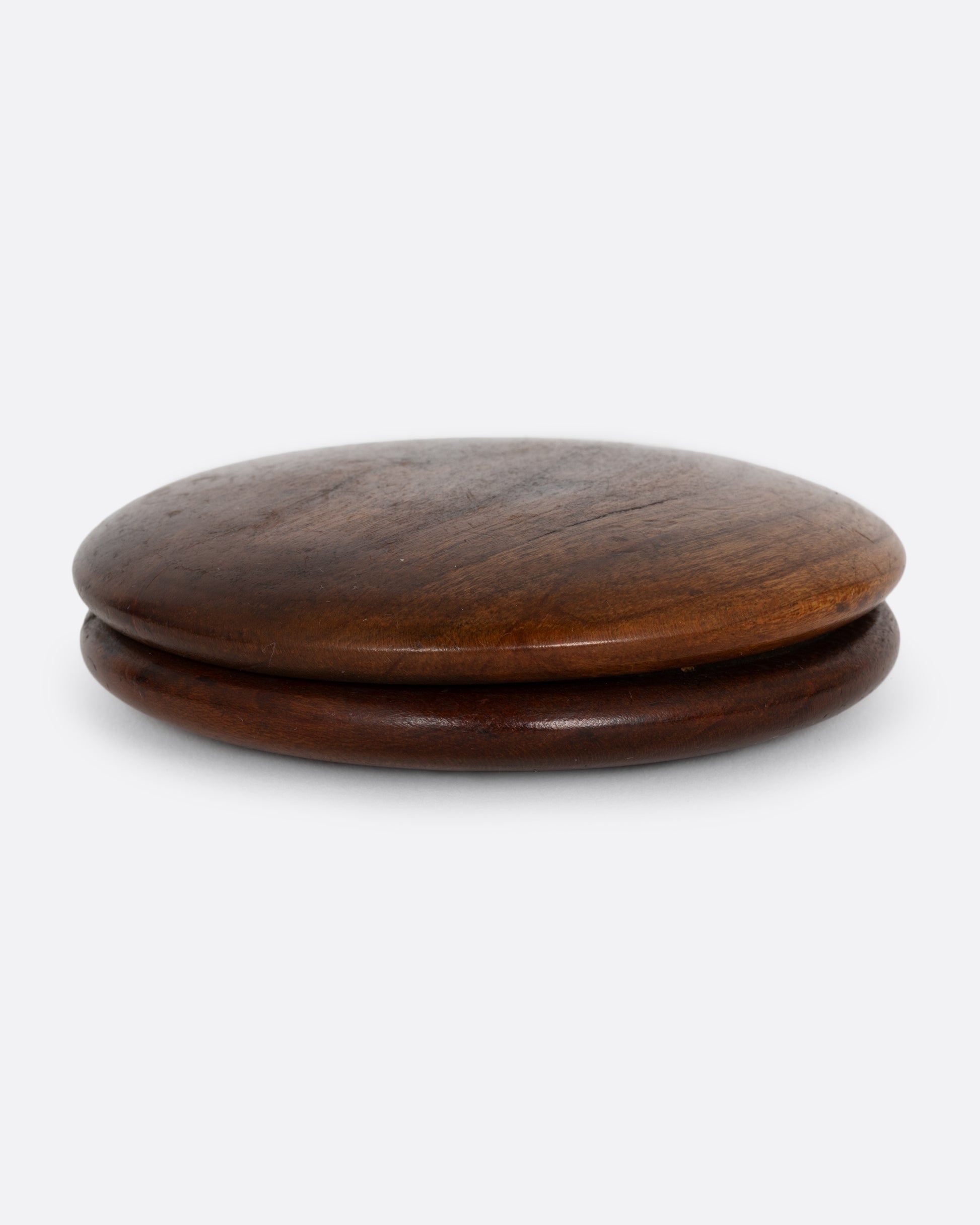 A round wooden snuff box shown open from the side.