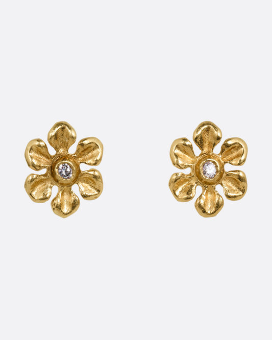A pair of yellow gold flower earrings with diamond centers. Shown from the front.