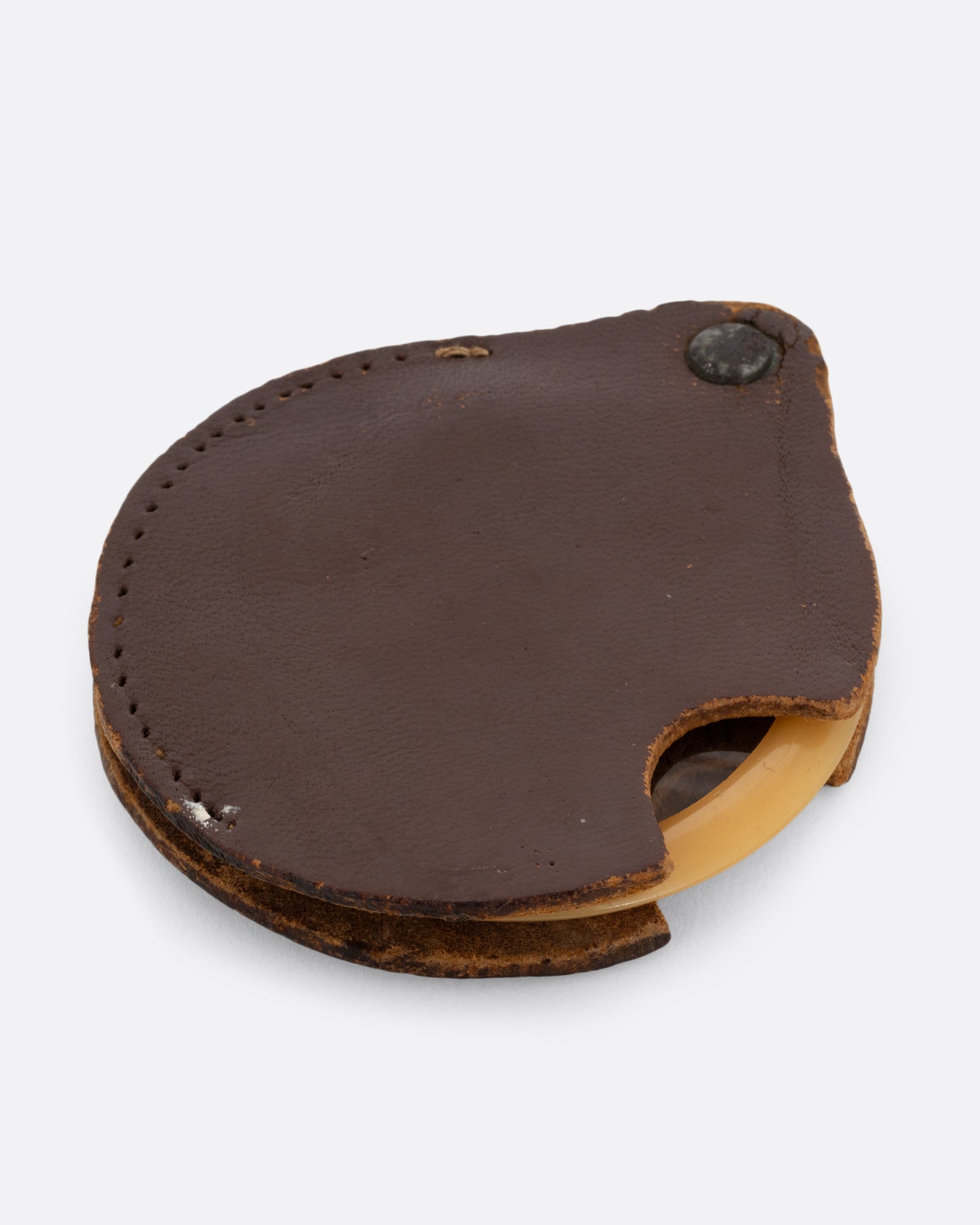 A plastic circular magnifying lens with a yellow edge. The lens slides out from a circular leather case. Shown closed from the front.