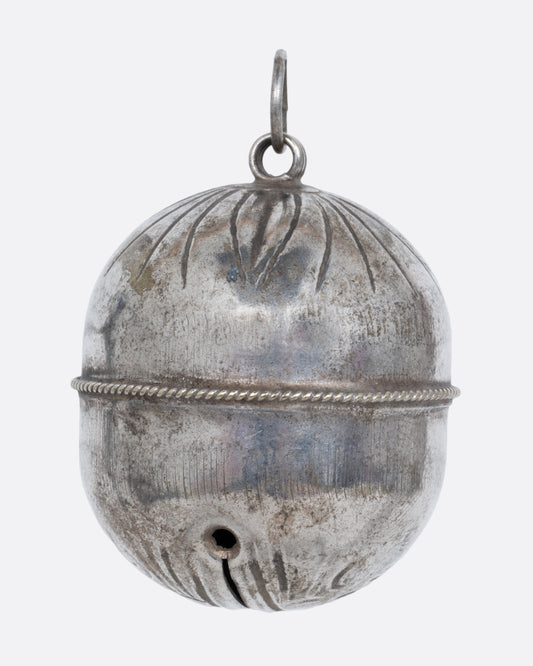  A silver engraved bell charm. Shown from the front.