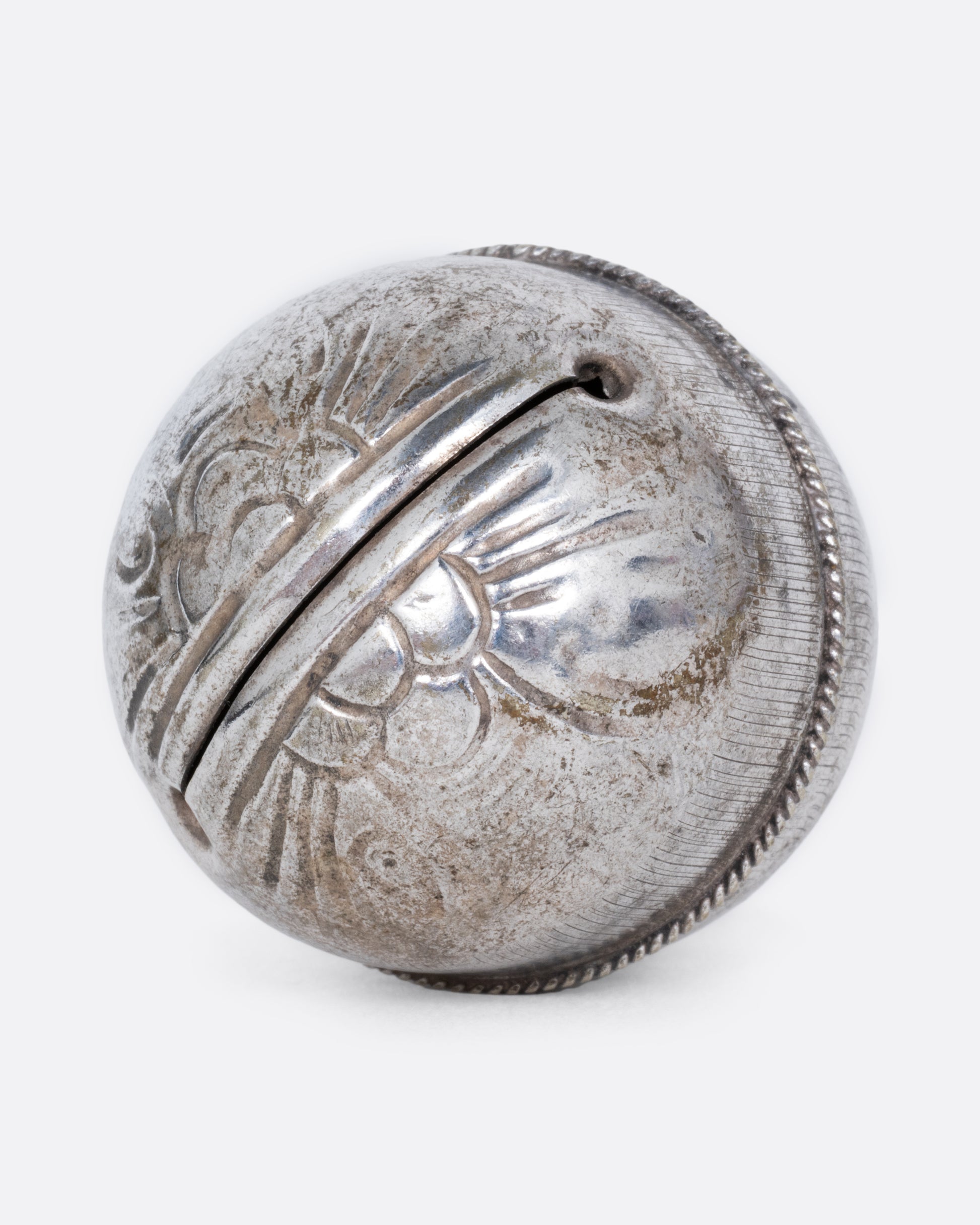  A silver engraved bell charm. Shown from the bottom.