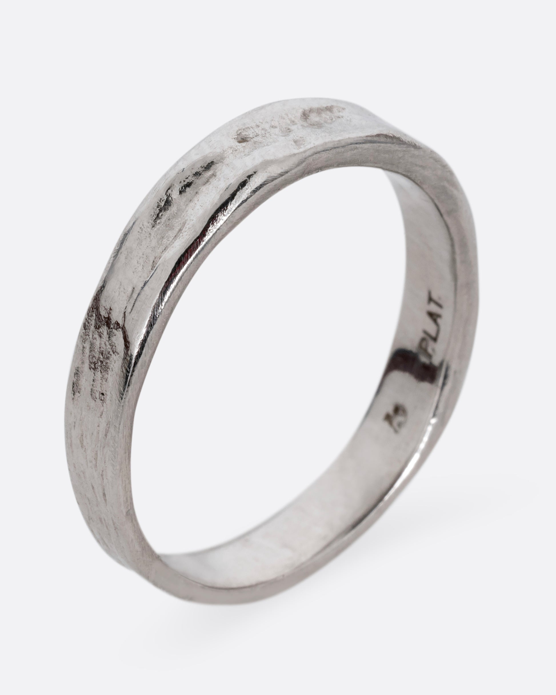 A platinum textured band with an irregular band, shown from the side, standing up.