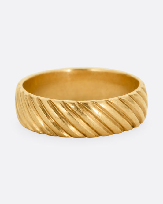 A wide yellow gold ring with an all over diagonal linear pattern. Shown from the front.