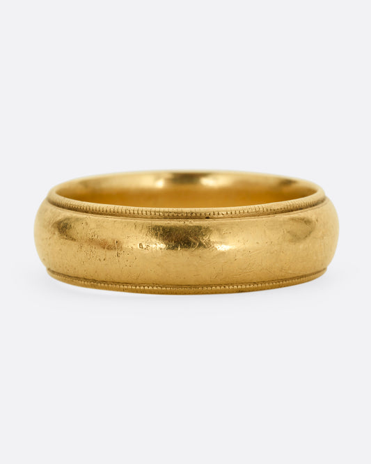 A yellow gold  rounded cigar band with a milgrain edge. Shown from the front.