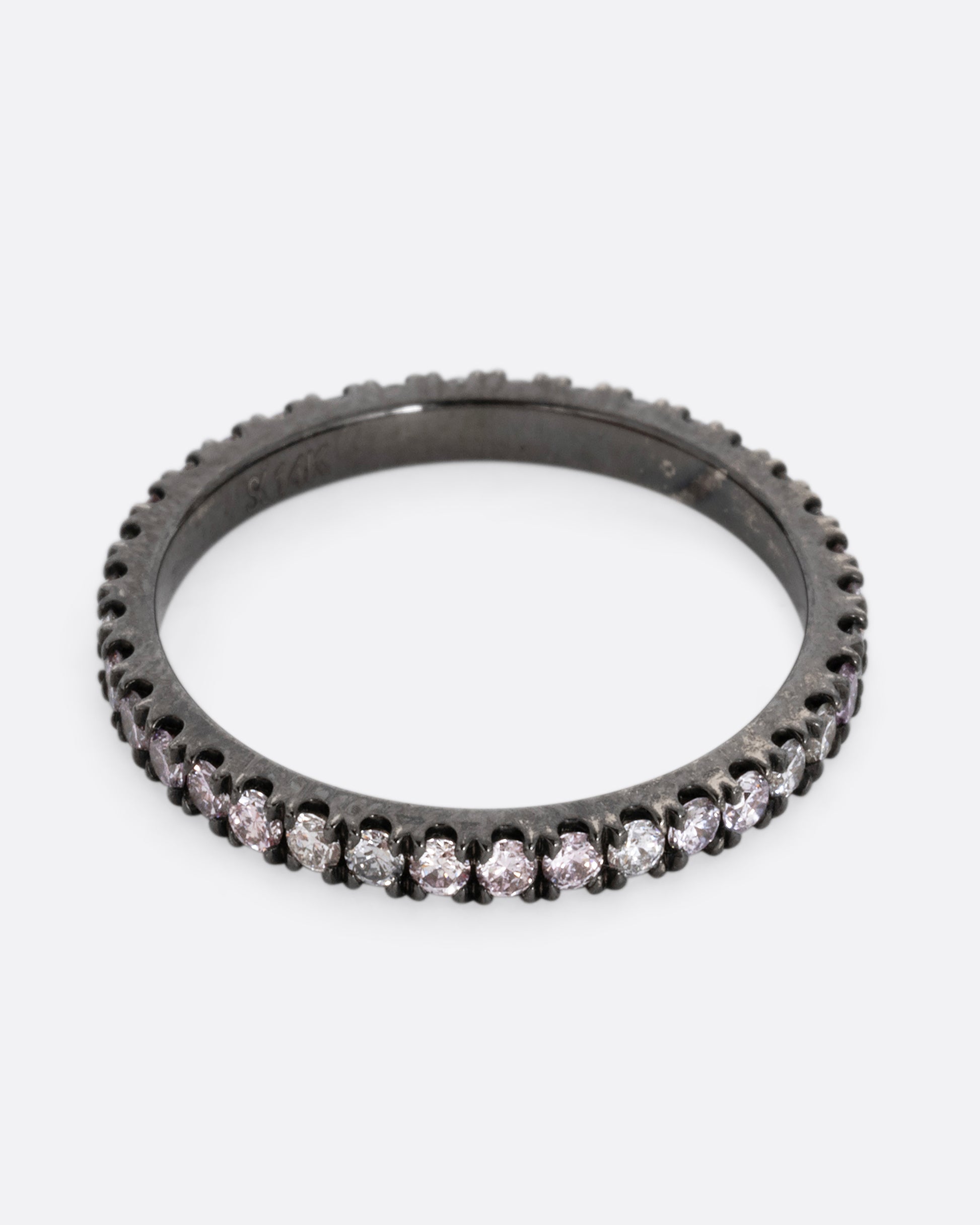 A white gold rhodium plated eternity band with pink, gray, and white diamonds. Shown from the front.