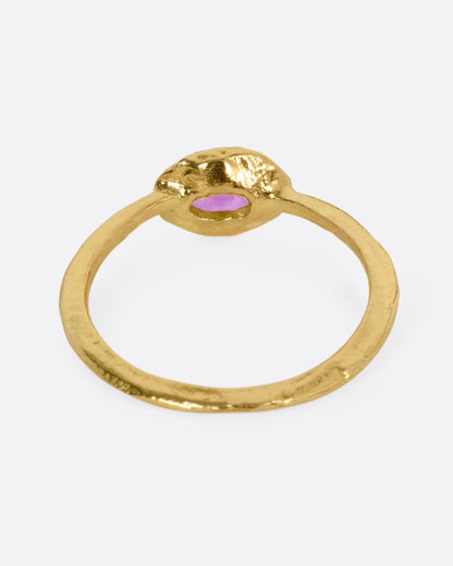 A yellow gold ring with an oval ruby, shown from the back.