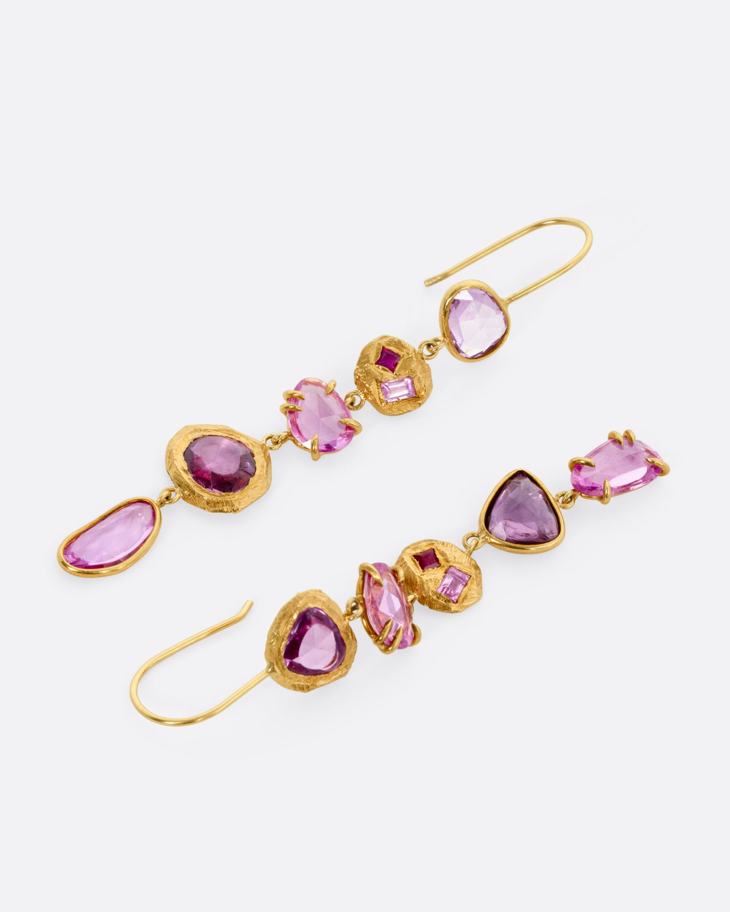 A pair of yellow gold drop earrings with pink sapphires and ruby and diamond accents, shown lying flat from the front.