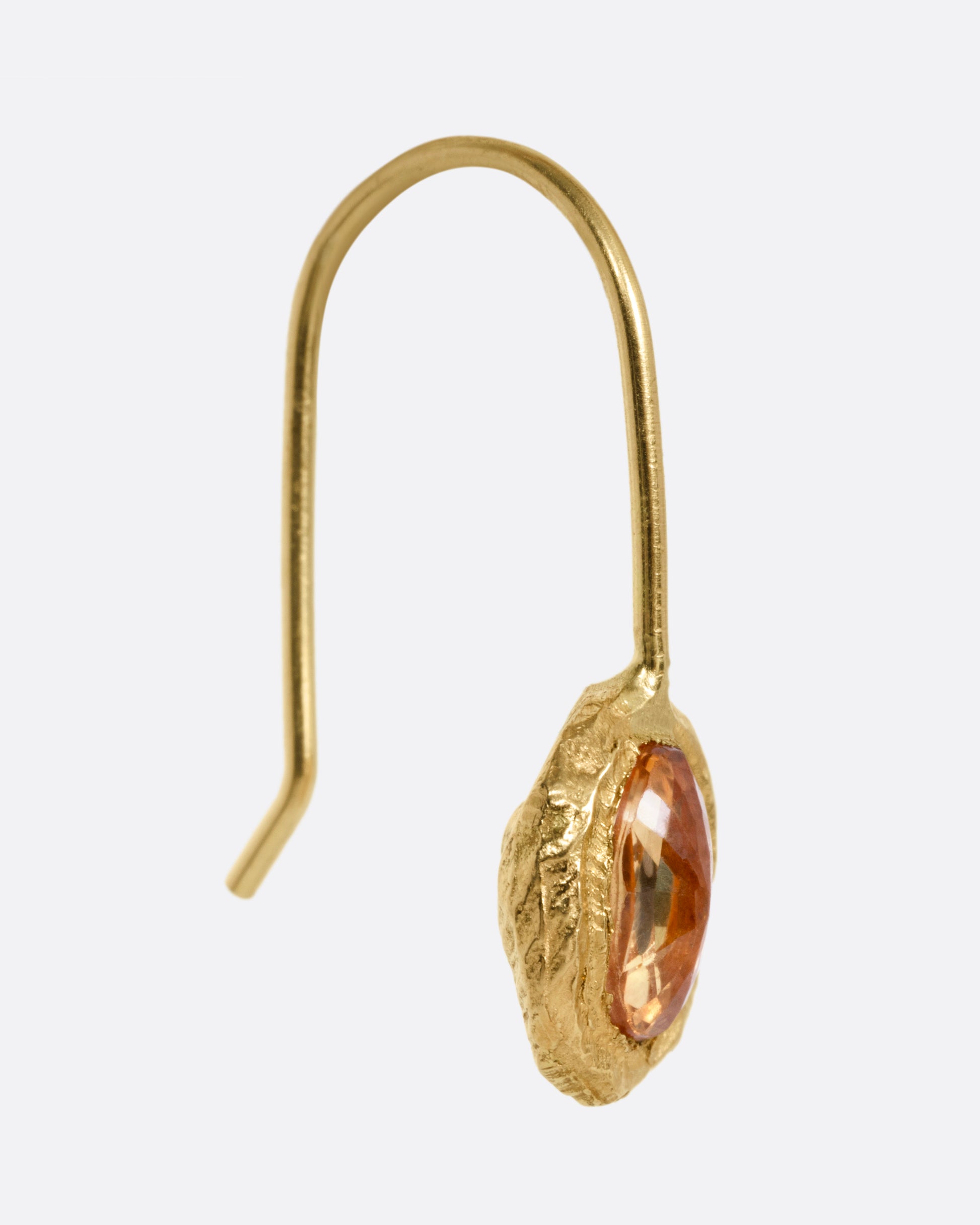 A yellow gold earring with a yellow sapphire, shown from the side.