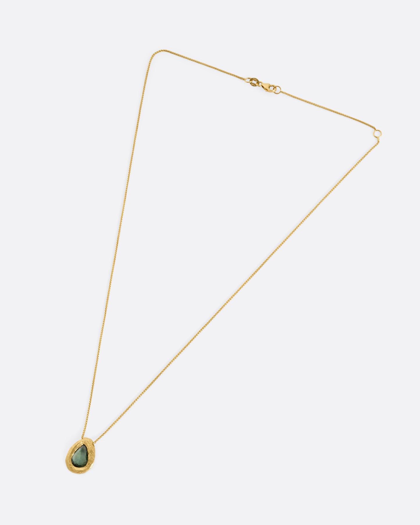 A yellow gold necklace with a green rose cut sapphire pendant, shown from the front.