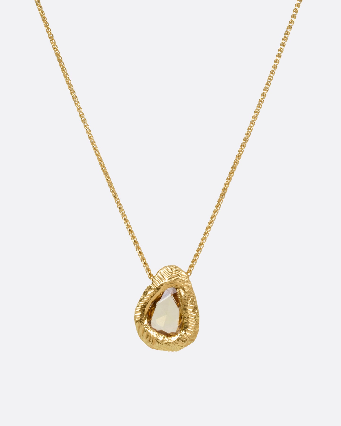 A yellow gold necklace with a yellow sapphire pendant, shown from the front.