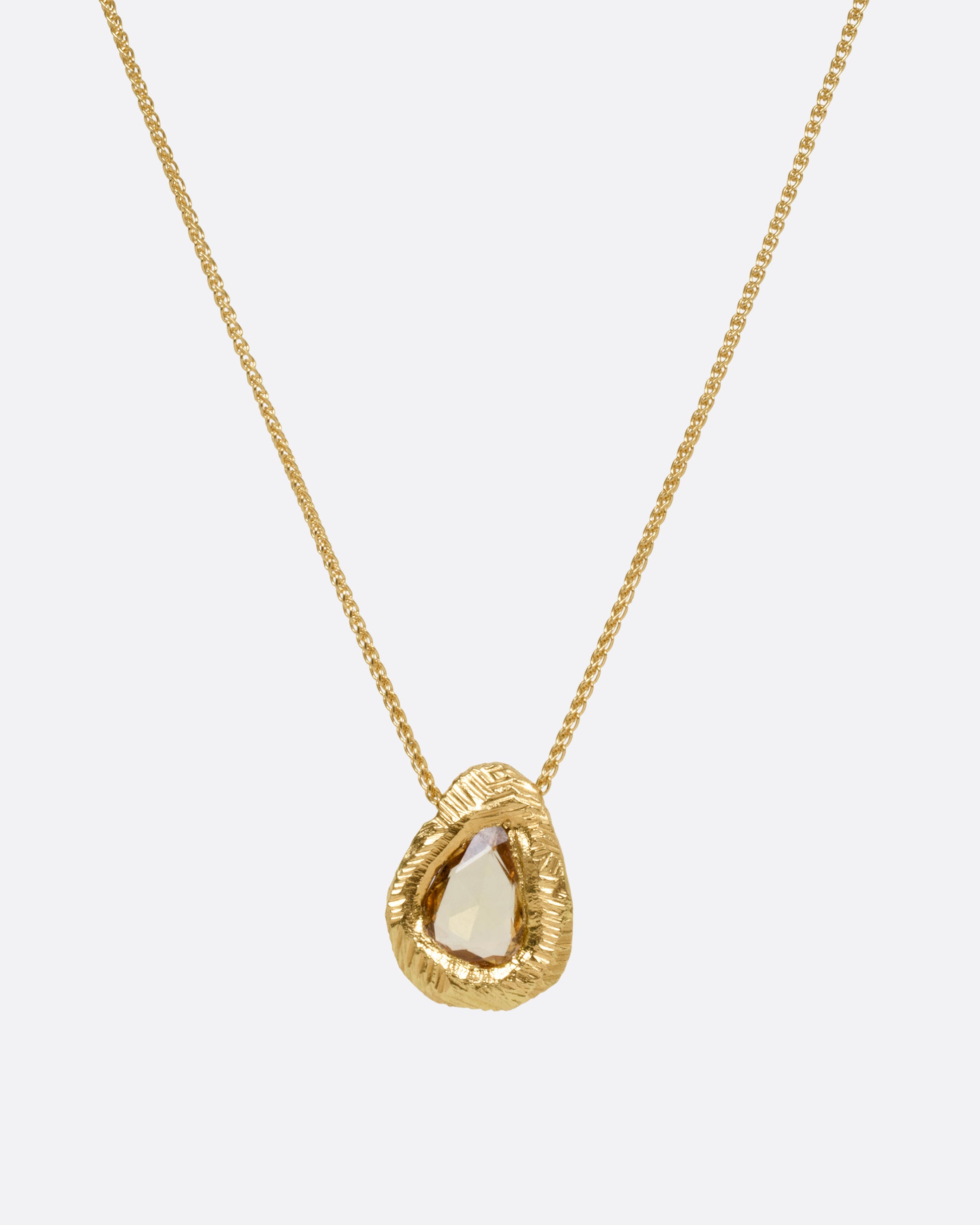 A yellow gold necklace with a yellow sapphire pendant, shown from the front.
