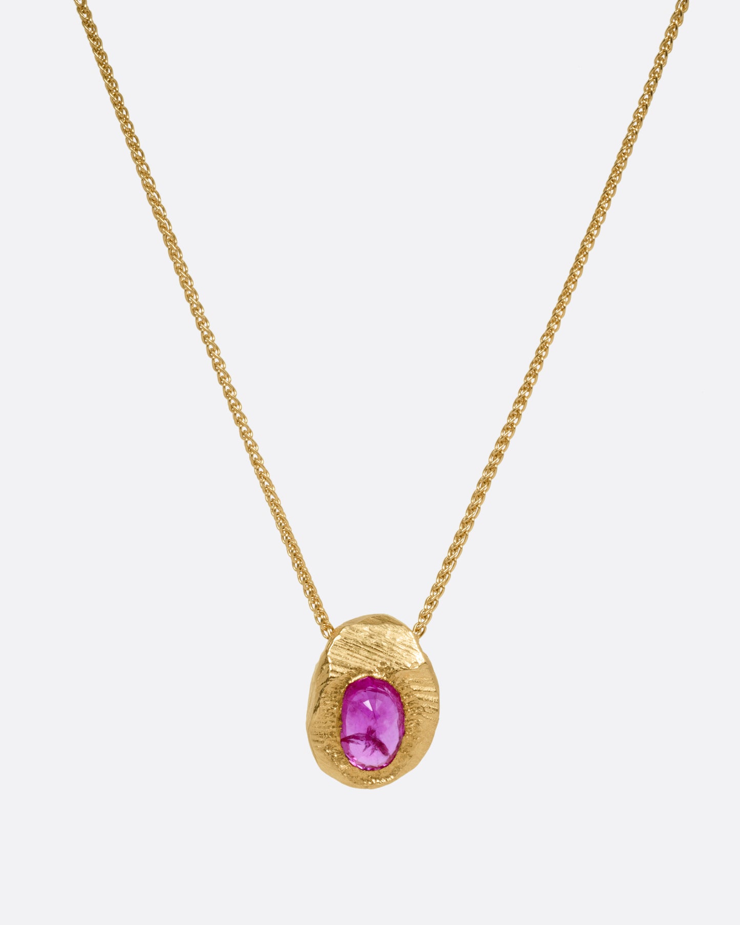 A yellow gold necklace with a ruby pendant shown from the front.