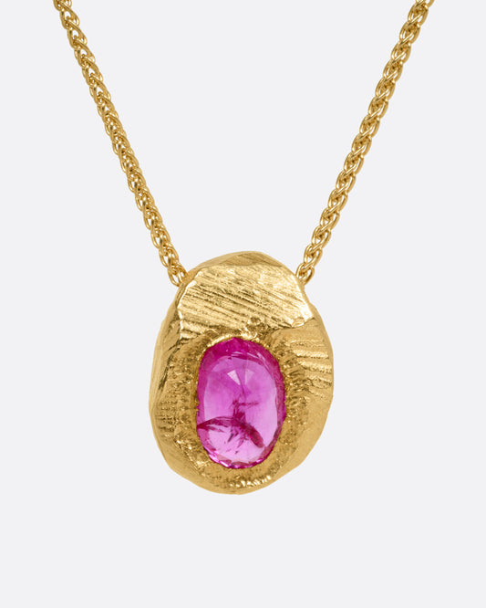 A yellow gold necklace with a ruby pendant shown from the front.