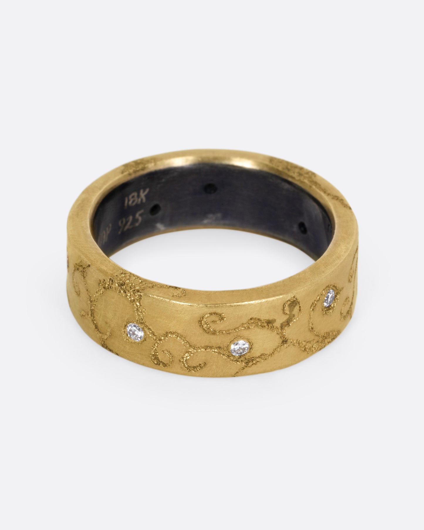 A yellow gold ring with etched oceanic images and diamond accents throughout, shown from the front.