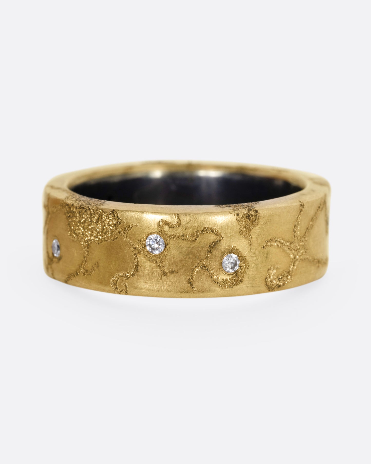 A yellow gold ring with etched oceanic images and diamond accents throughout, shown from the front.