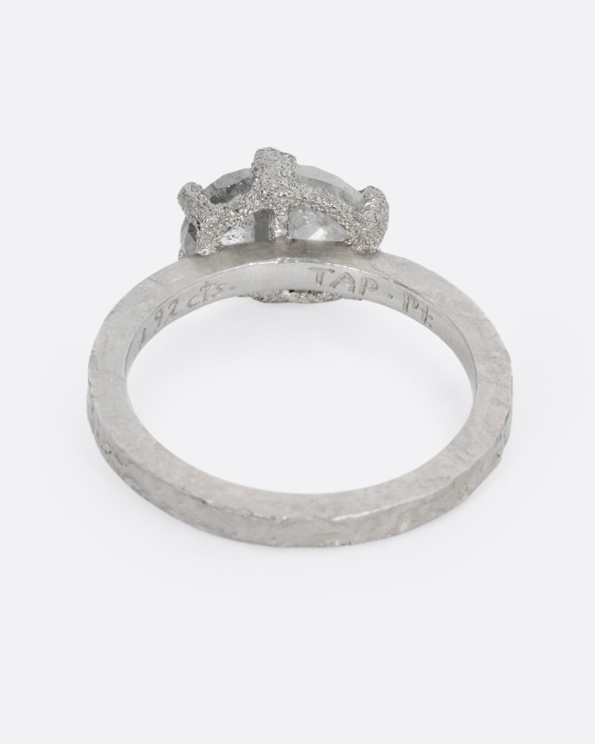 A platinum ring with two prong set rose cut diamonds, shown from the back.