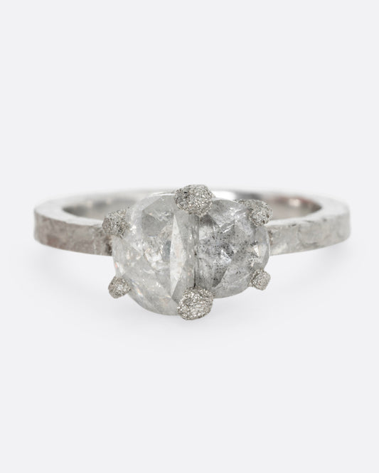A platinum ring with two prong set rose cut diamonds, shown from the front.
