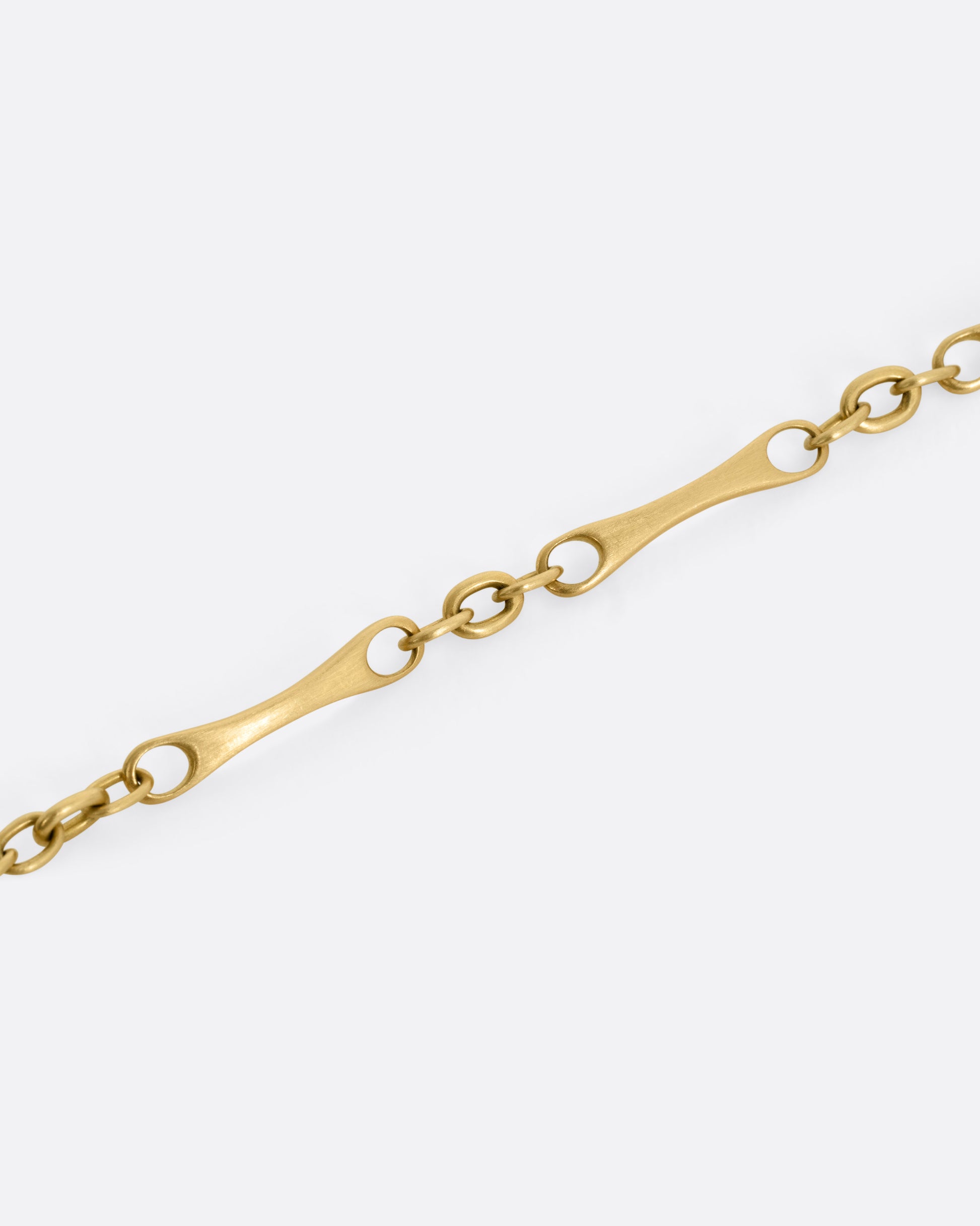 A close up of a yellow gold link bracelet.
