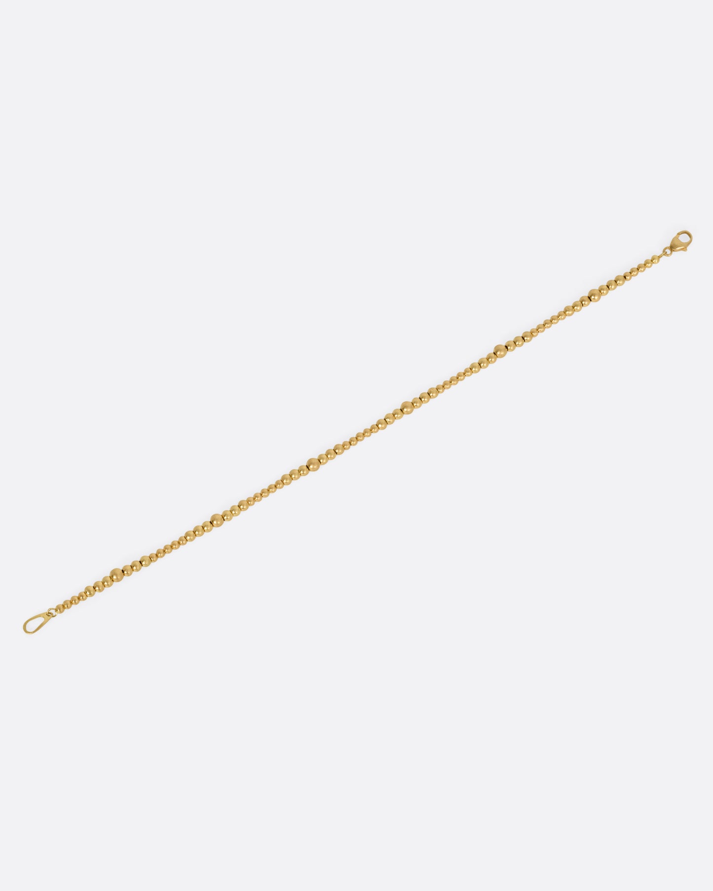 A yellow gold bracelet with graduated beads, shown from the front.