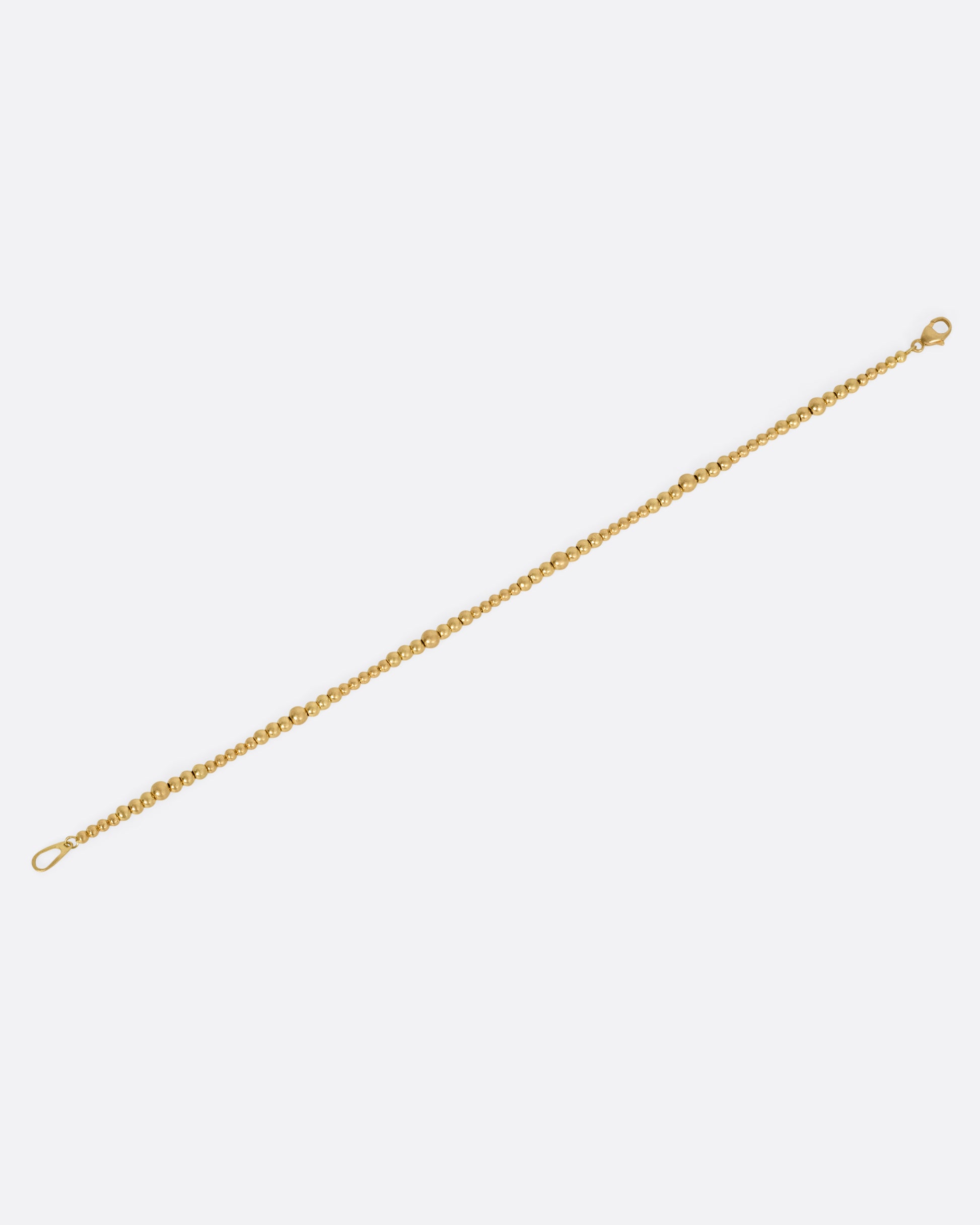 A yellow gold bracelet with graduated beads, shown from the front.
