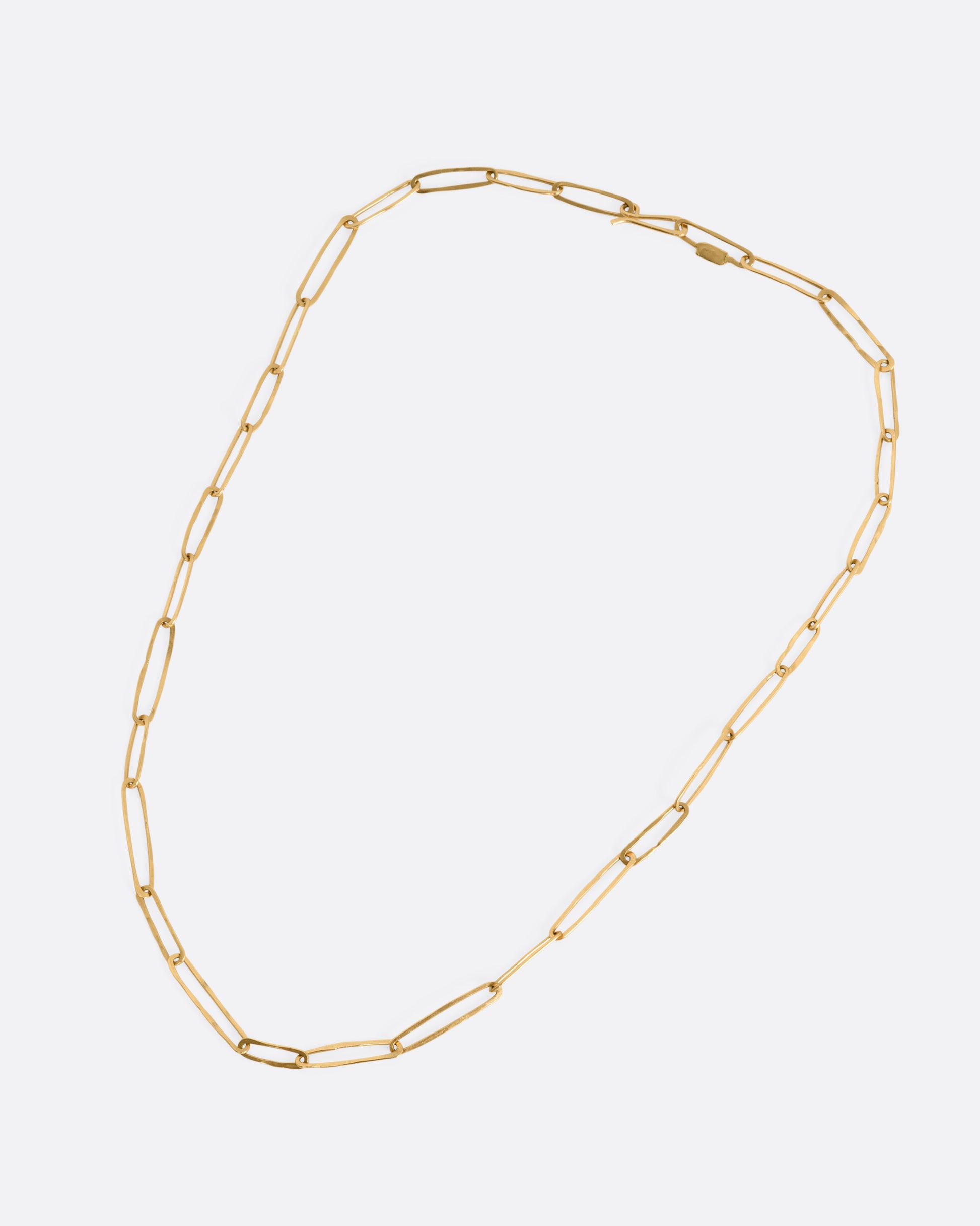 A yellow gold paperclip chain shown from the front.