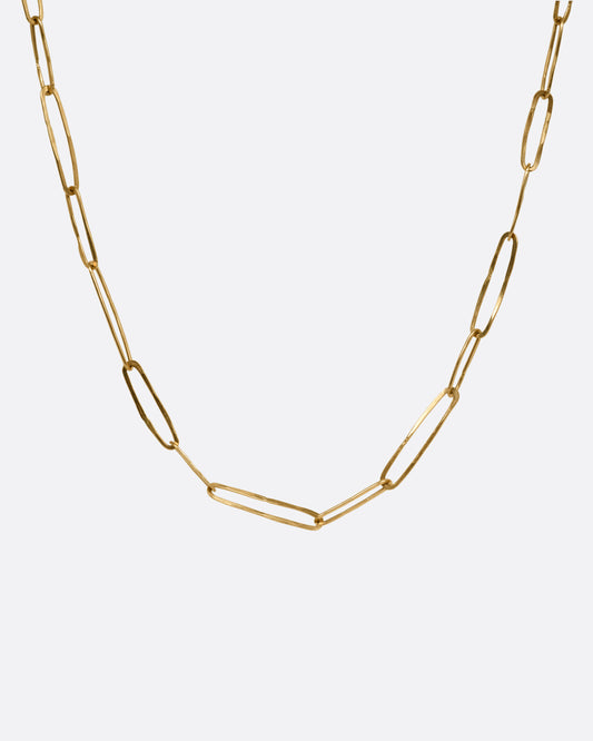A yellow gold paperclip chain shown from the front.