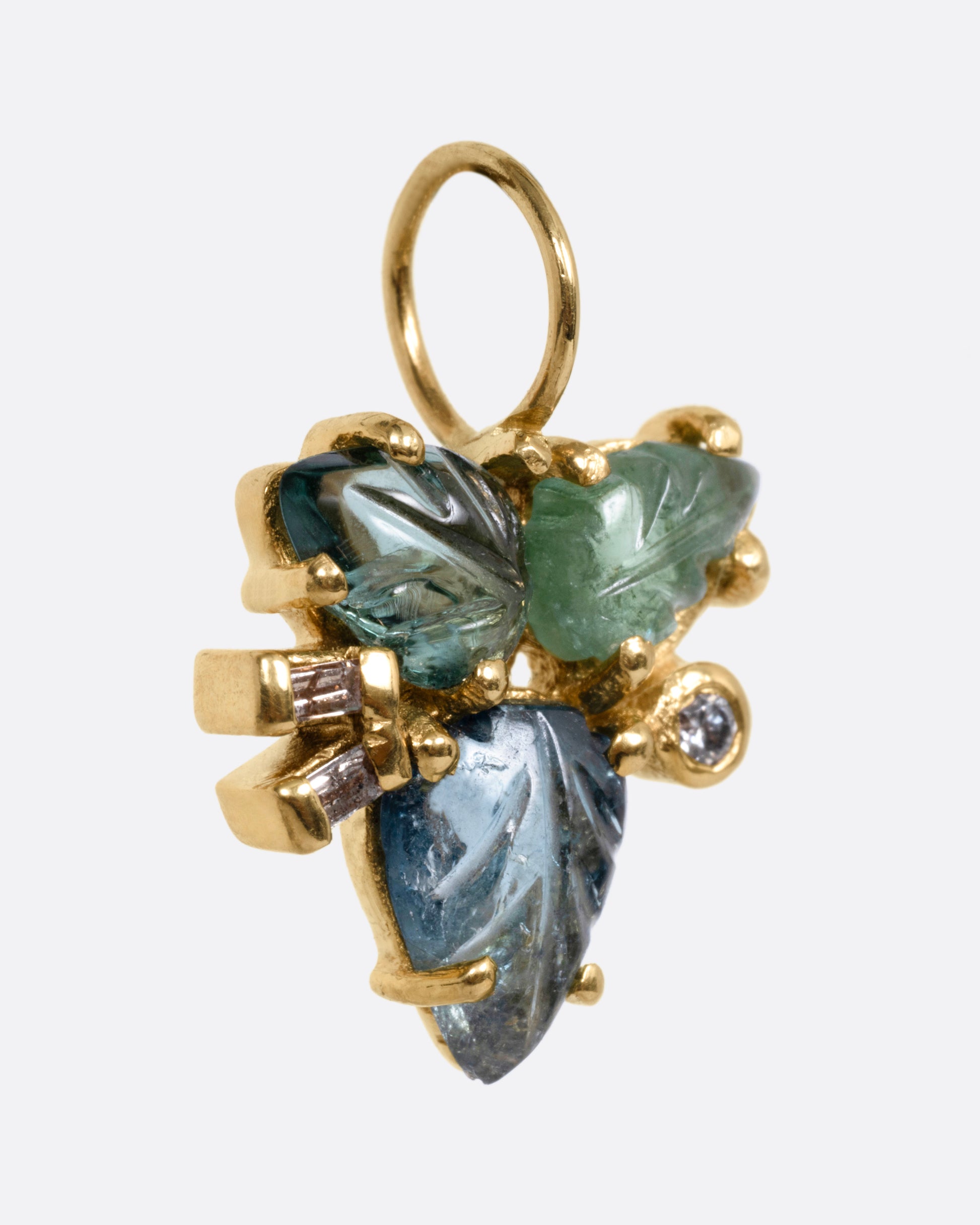 A yellow gold pendant with tourmalines and diamonds, in a botanical shape, shown from the side.