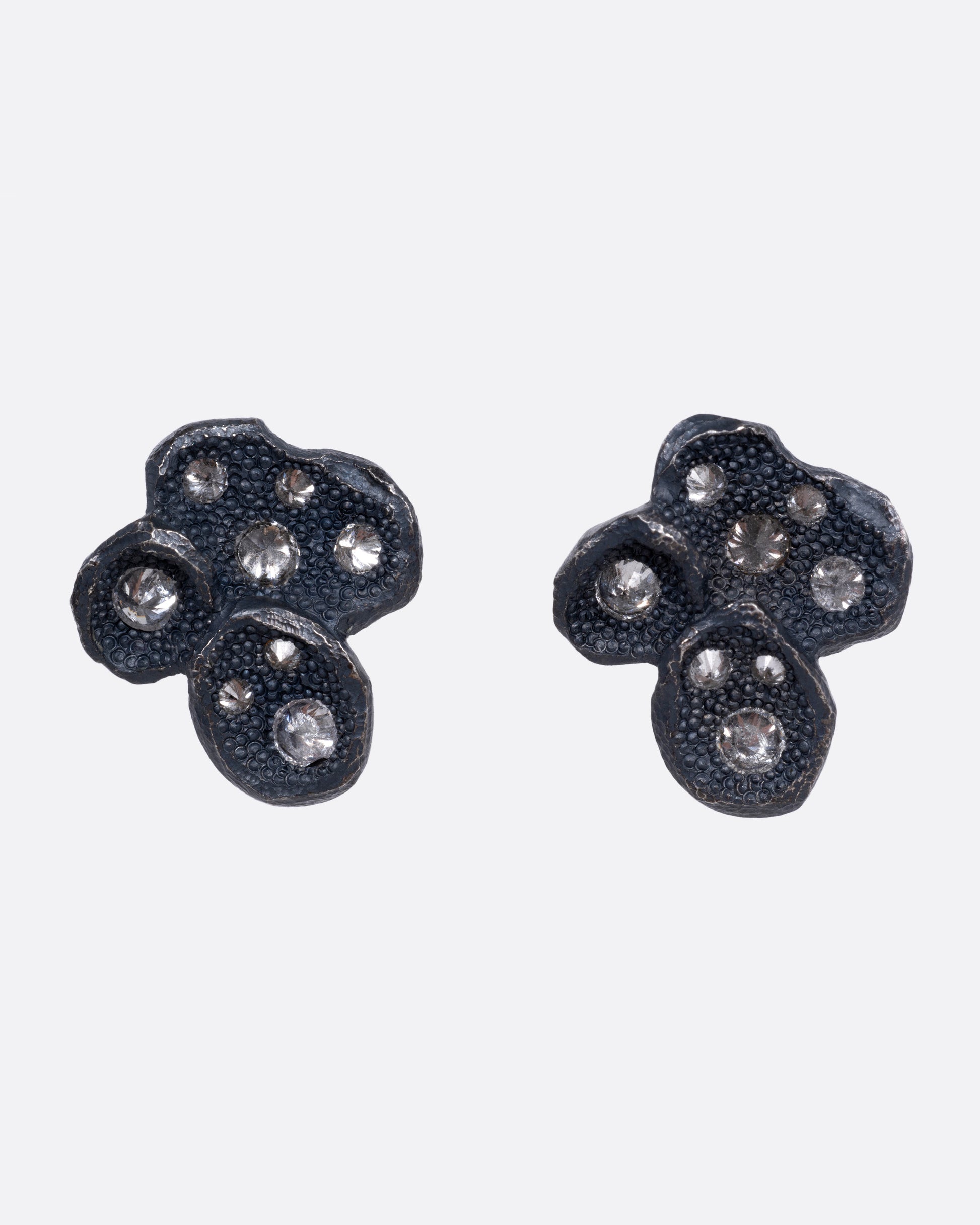 A pair of black oxidized stud earrings with inverted diamonds, shown from the front.