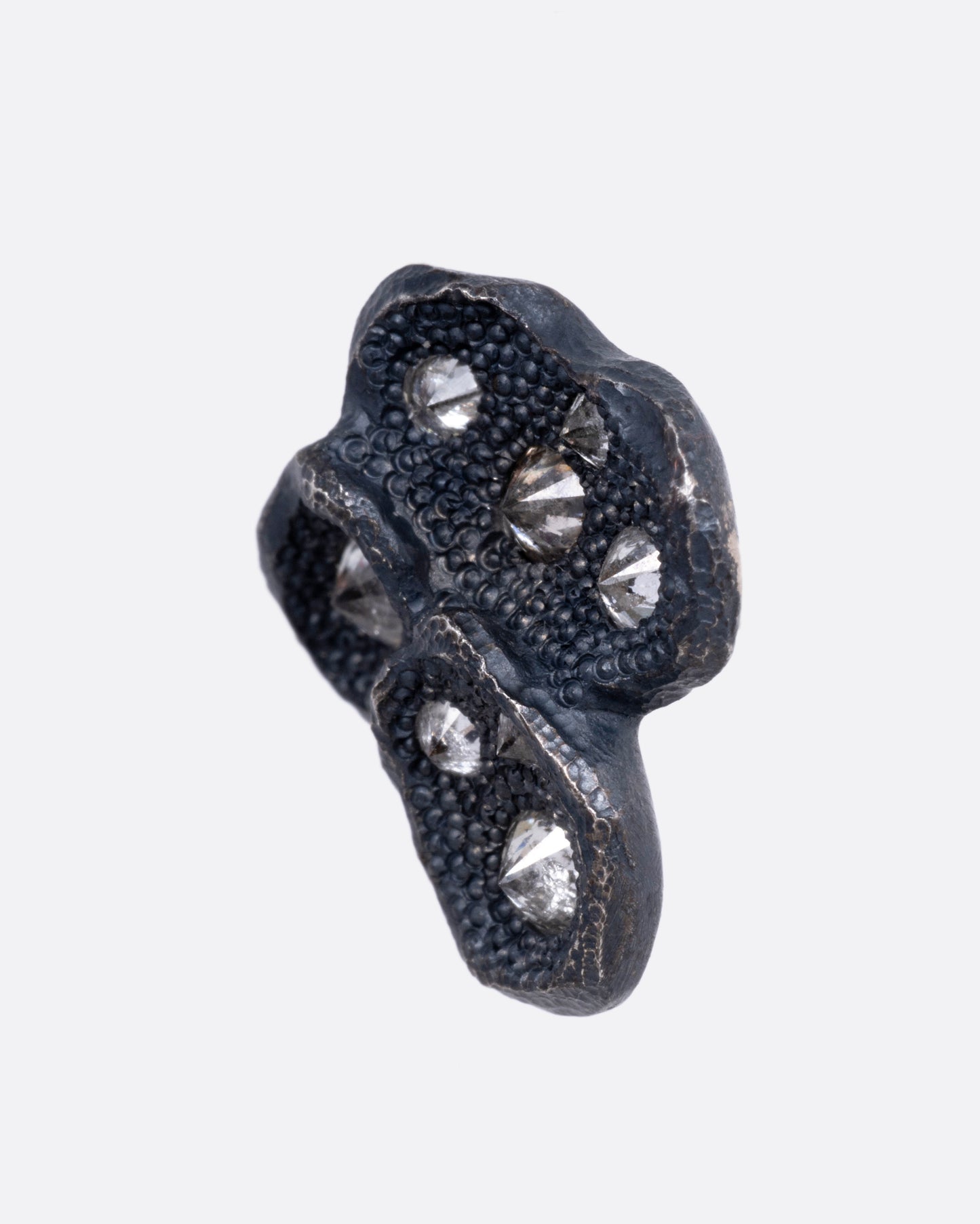 A black oxidized stud earring with inverted diamonds, shown from the side.