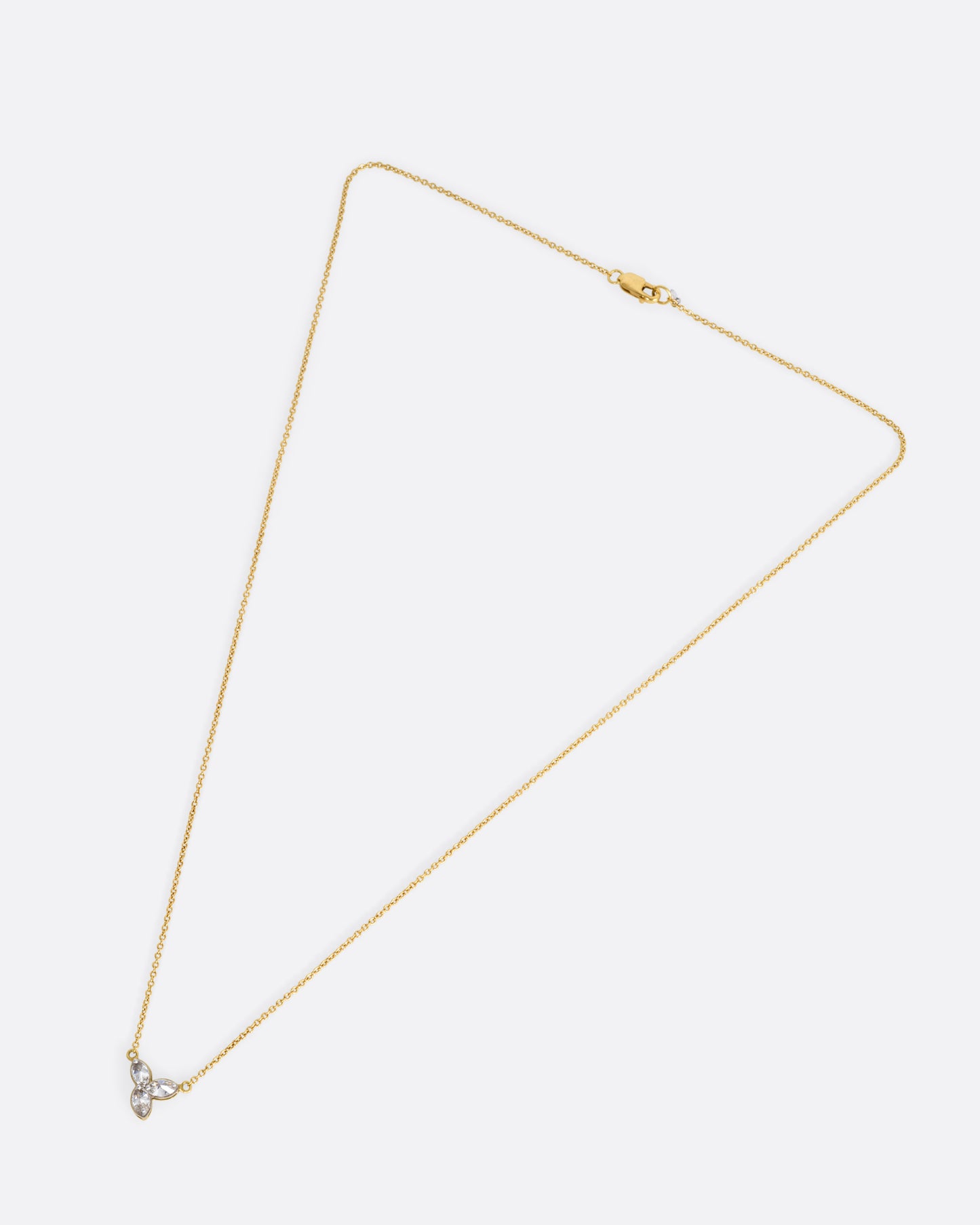 A yellow gold cable chain necklace with a pendant of  three inverted marquise diamonds, shown from the front.