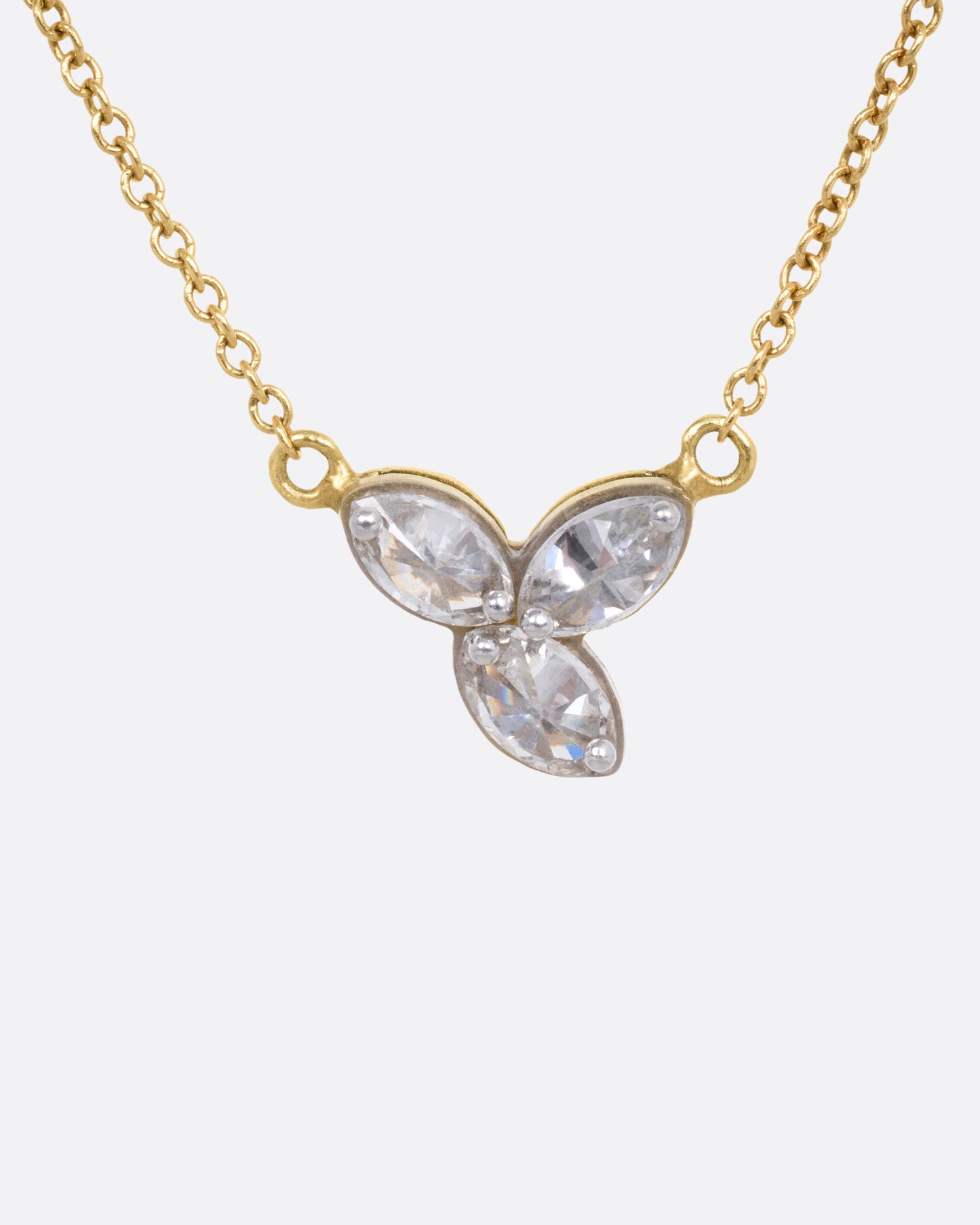 A yellow gold cable chain necklace with a pendant of  three inverted marquise diamonds, shown from the front.