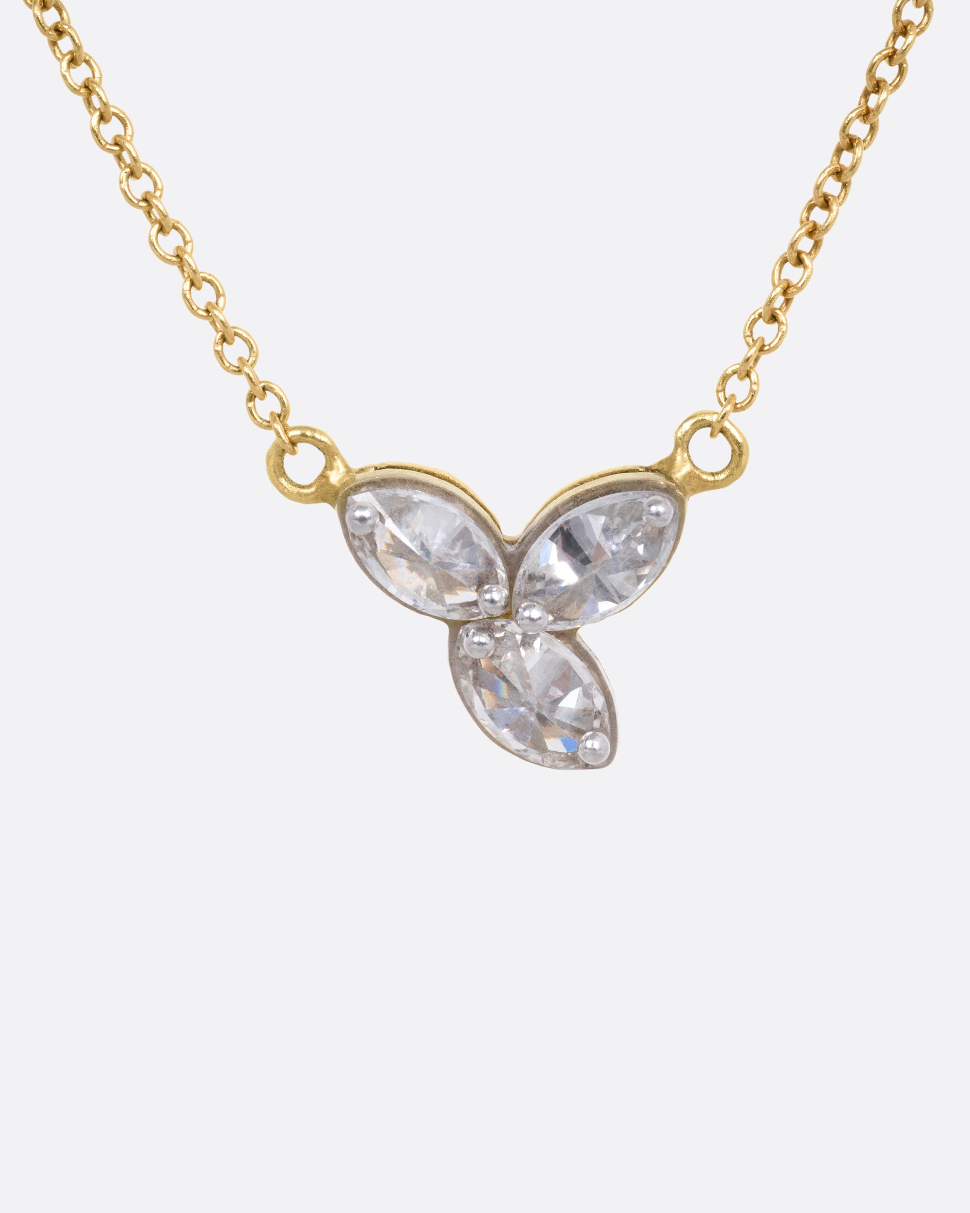 A yellow gold cable chain necklace with a pendant of  three inverted marquise diamonds, shown from the front.