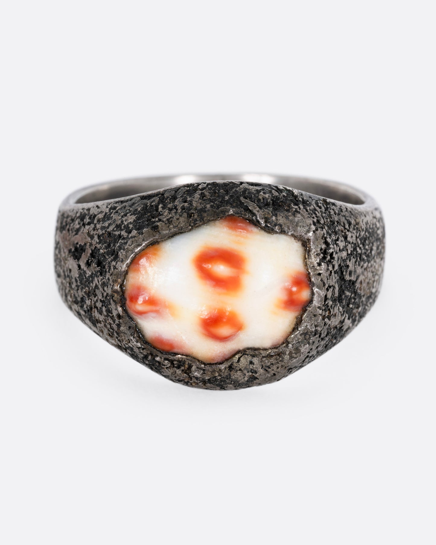 A silver signet ring with a speckled shell, shown from the front.