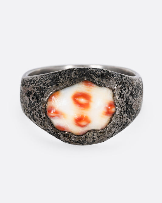 A silver signet ring with a speckled shell, shown from the front.