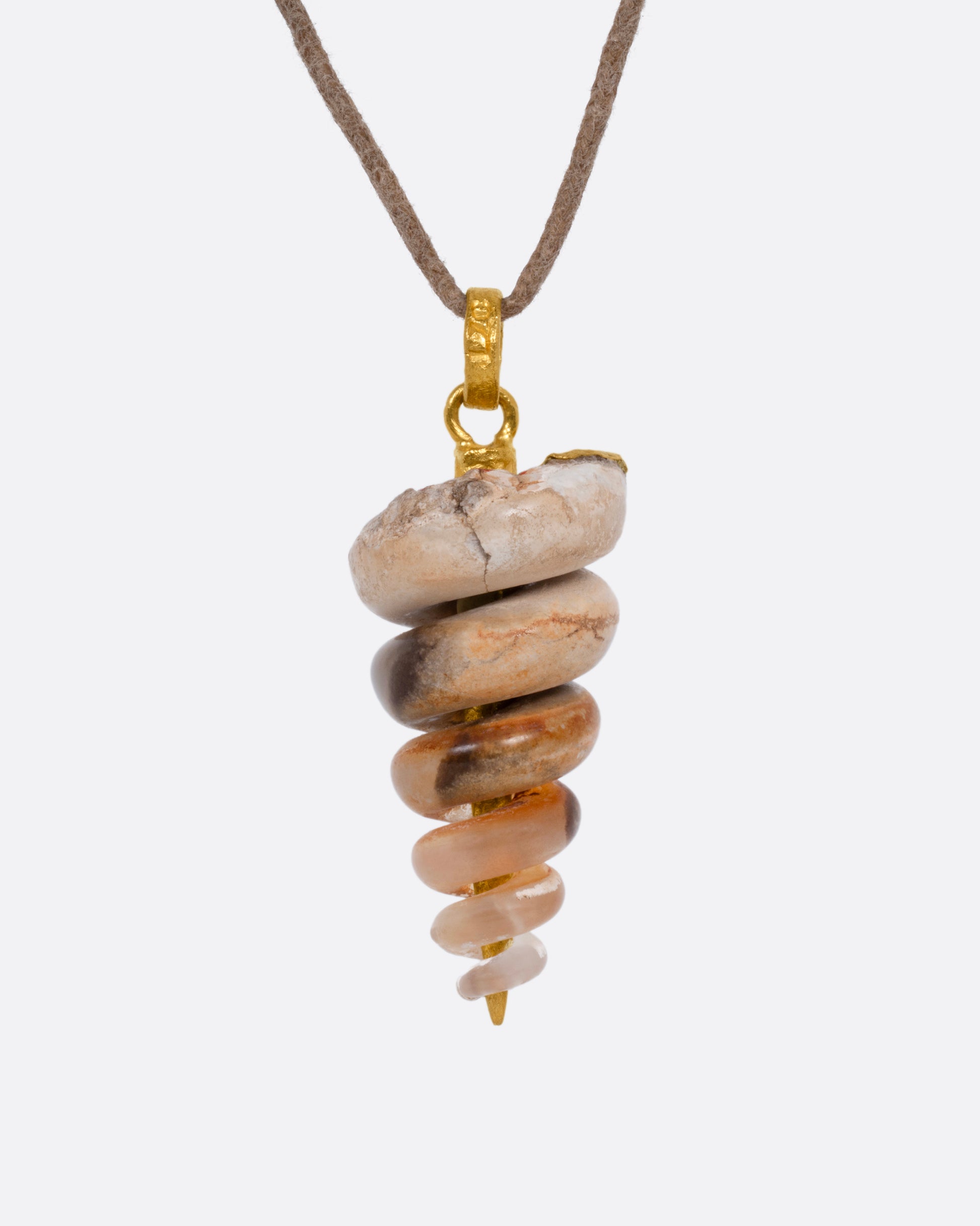 A yellow gold pendant with a  fossilized snail on a cord, shown from the front.