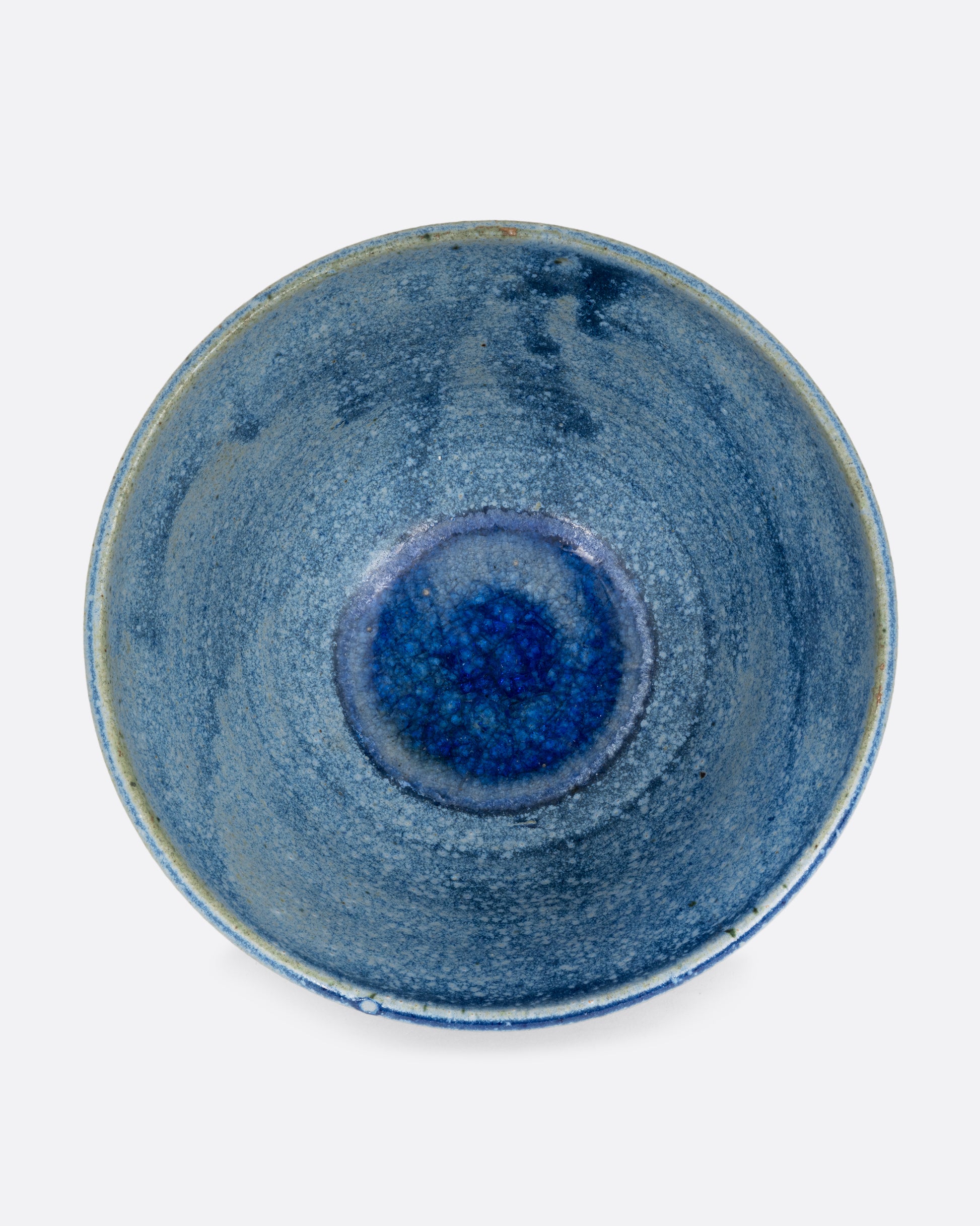 A blue ceramic bowl with brown squiggles around its middle. Shown from the top.